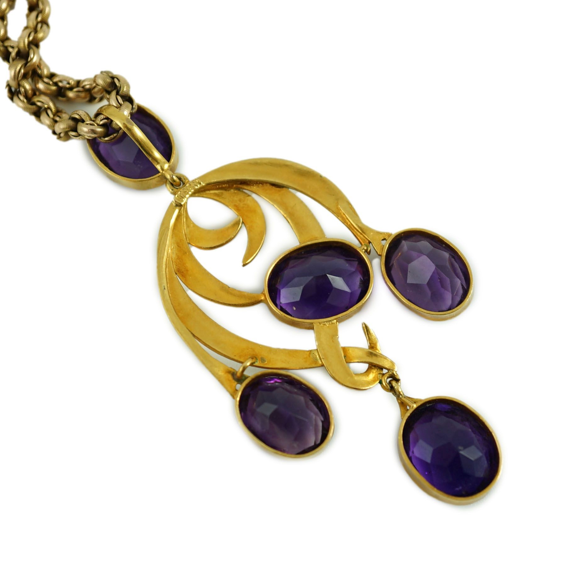 An early 20th century continental gold, enamel and five stone oval cut amethyst set drop pendant, of scrolling design